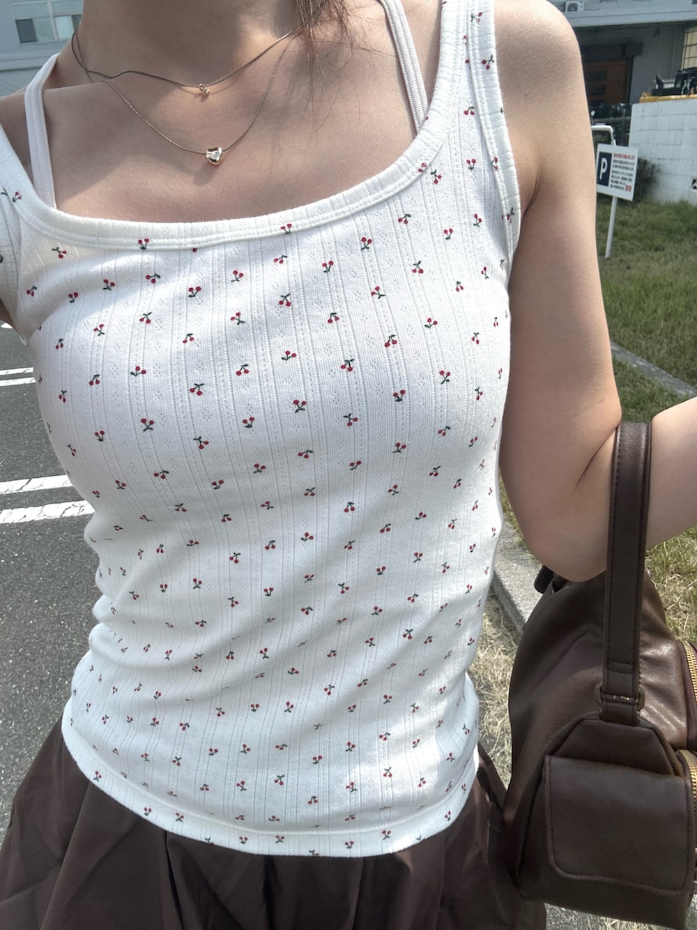 シルバー系のパンプス、その他のタンクトップ、ホワイト系のキャミソールを着用したレディースの夏コーディネートの3枚目の写真