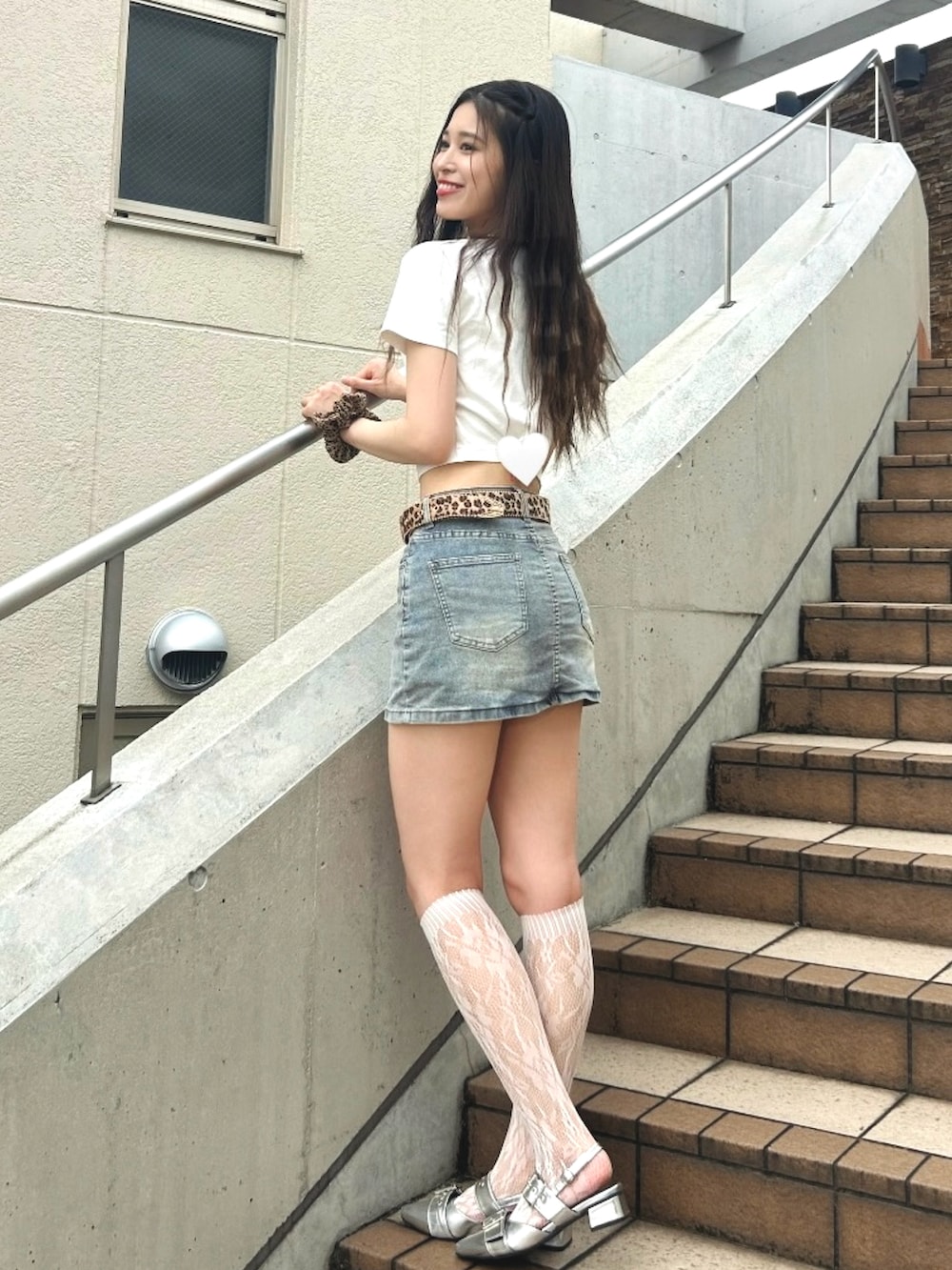 シルバー系のパンプス、ホワイト系のTシャツ/カットソー、ブルー系のデニムスカートを着用したレディースの夏コーディネートの3枚目の写真