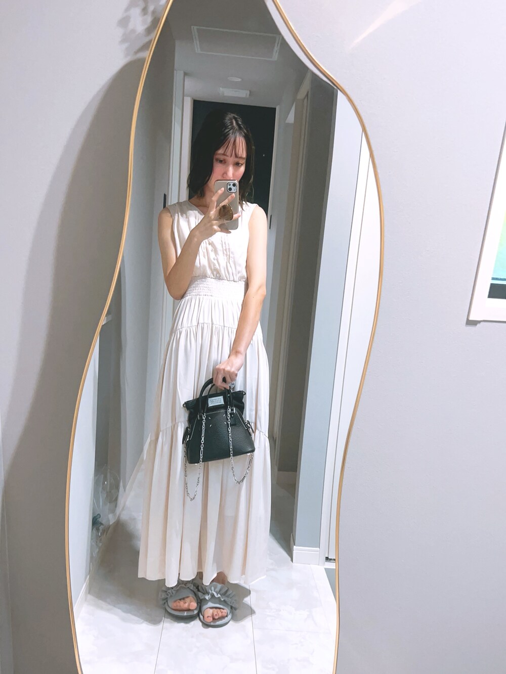 ベージュ系のワンピース/ドレス、ブラック系のハンドバッグを着用したレディースの夏コーディネートの2枚目の写真