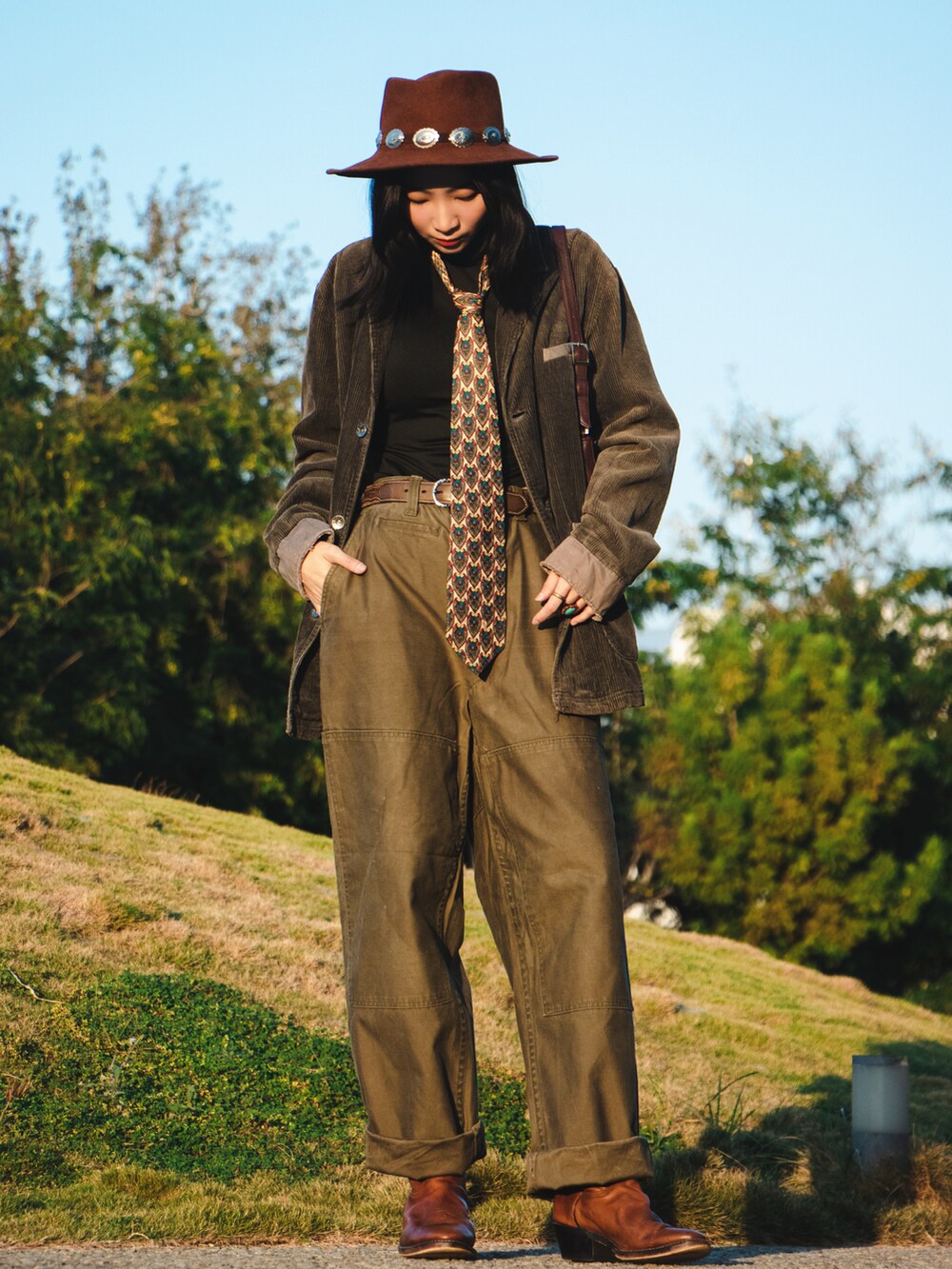 その他のネクタイ、グリーン系のパンツ、ブラウン系のブーツを着用したレディースの秋コーディネートの2枚目の写真