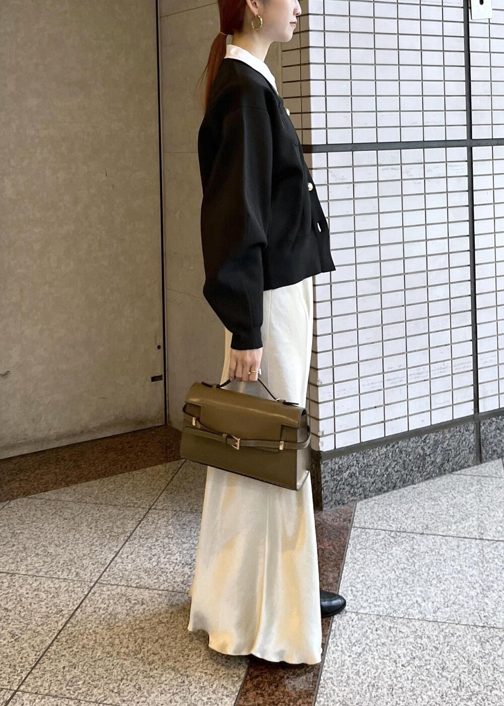 ベージュ系のスカート、ベージュ系のショルダーバッグ、ブラック系のローファーを着用したレディースの冬コーディネートの3枚目の写真