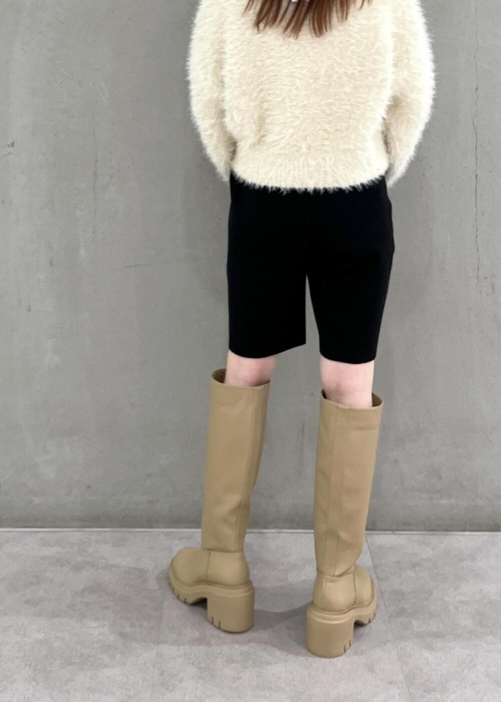 ホワイト系のニット/セーター、ベージュ系のブーツ、ブラック系のその他パンツを着用したレディースの夏コーディネートの4枚目の写真