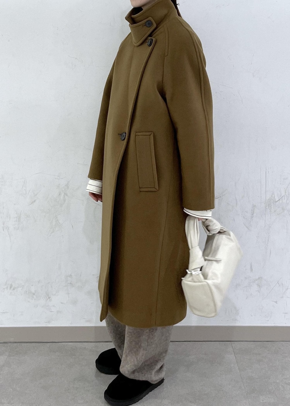 ホワイト系のハンドバッグ、イエロー系のステンカラーコート、ベージュ系のニット/セーターを着用したレディースの秋コーディネートの8枚目の写真