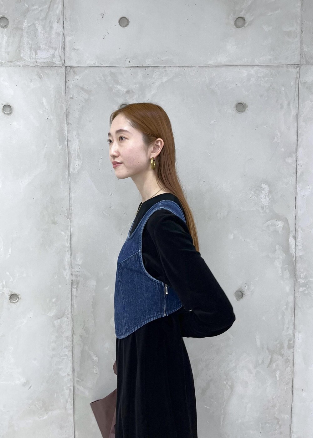 ブラック系のブーツ、ブラック系のワンピース、ブルー系のベストを着用したレディースの秋コーディネートの5枚目の写真