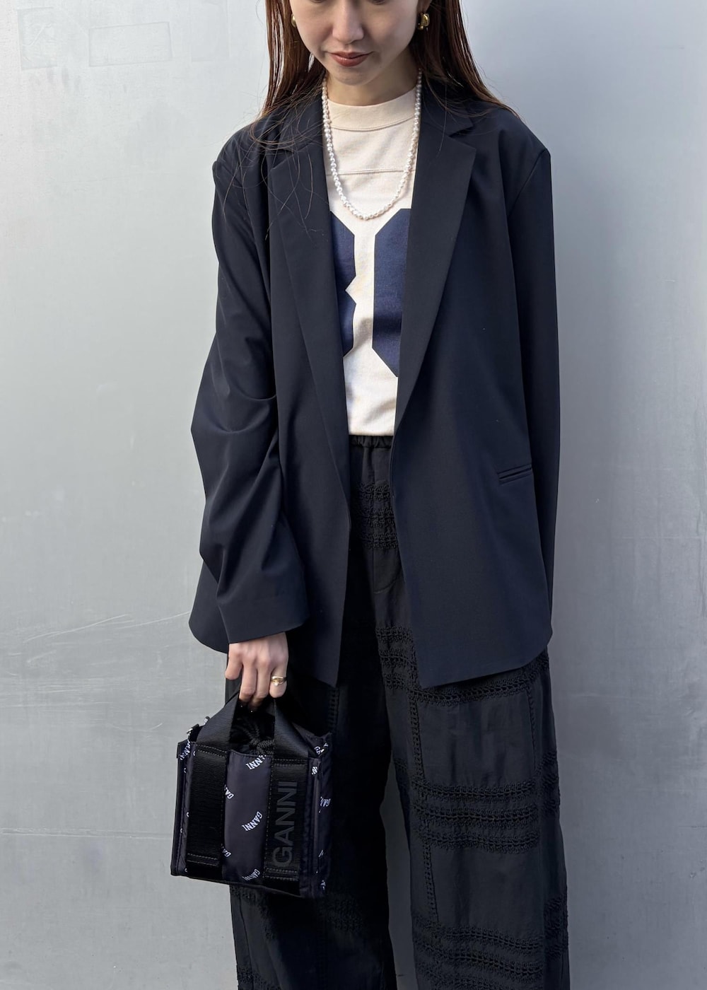 イエロー系のサンダル、ブラック系のトートバッグ、ホワイト系のネックレスを着用したレディースの冬コーディネートの7枚目の写真