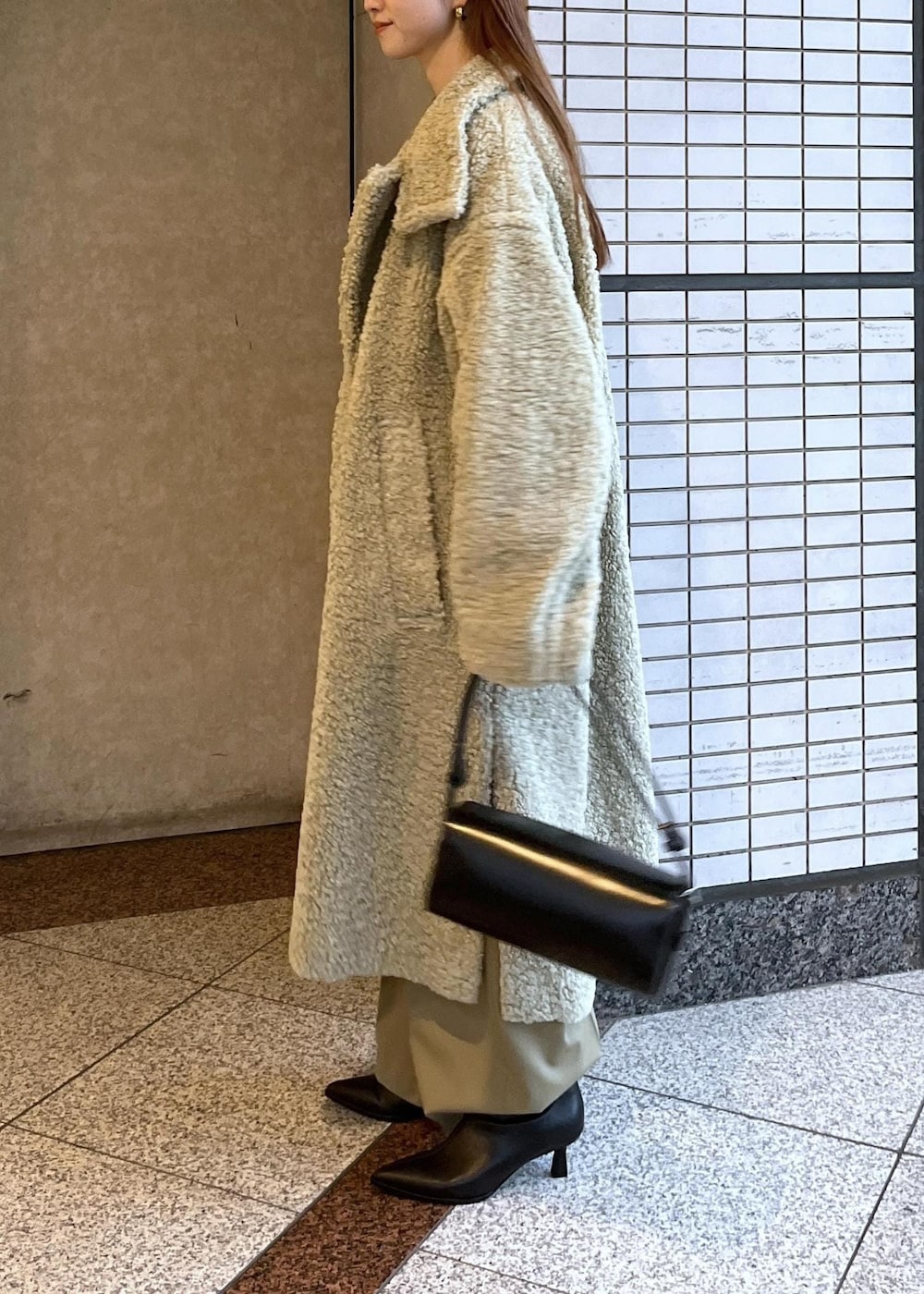 ブラック系のブーツ、ホワイト系のカーディガン/ボレロ、グリーン系のその他アウターを着用したレディースの冬コーディネートの4枚目の写真