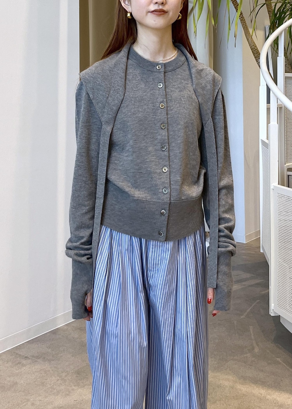 ブラウン系のサンダル、ブルー系のスラックス、グレー系のカーディガン/ボレロを着用したレディースの秋コーディネートの6枚目の写真