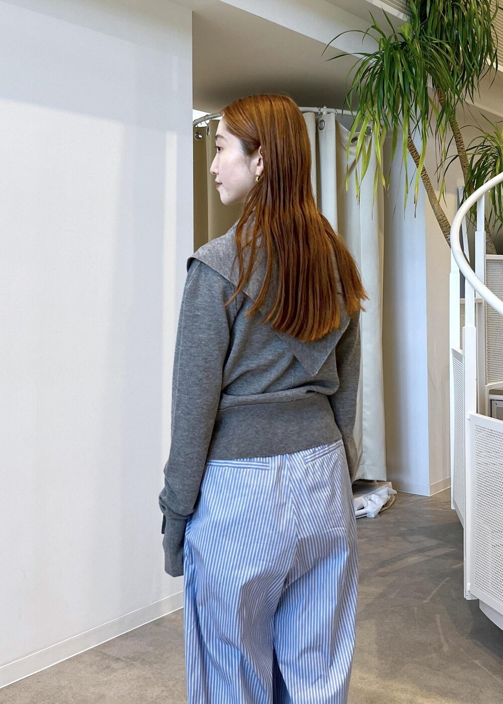 ブラウン系のサンダル、ブルー系のスラックス、グレー系のカーディガン/ボレロを着用したレディースの秋コーディネートの8枚目の写真