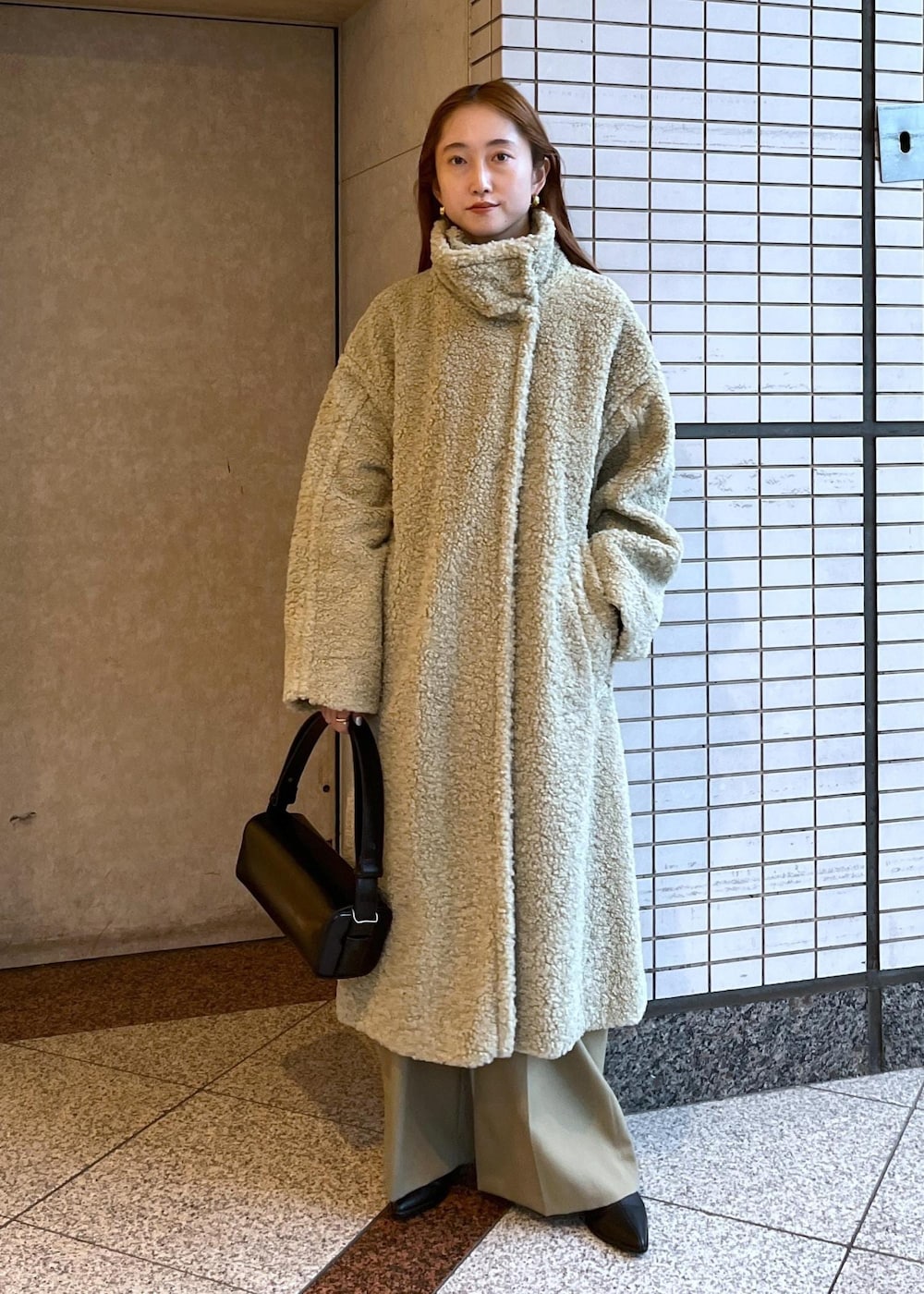 ブラック系のブーツ、ホワイト系のカーディガン/ボレロ、グリーン系のその他アウターを着用したレディースの冬コーディネートの2枚目の写真