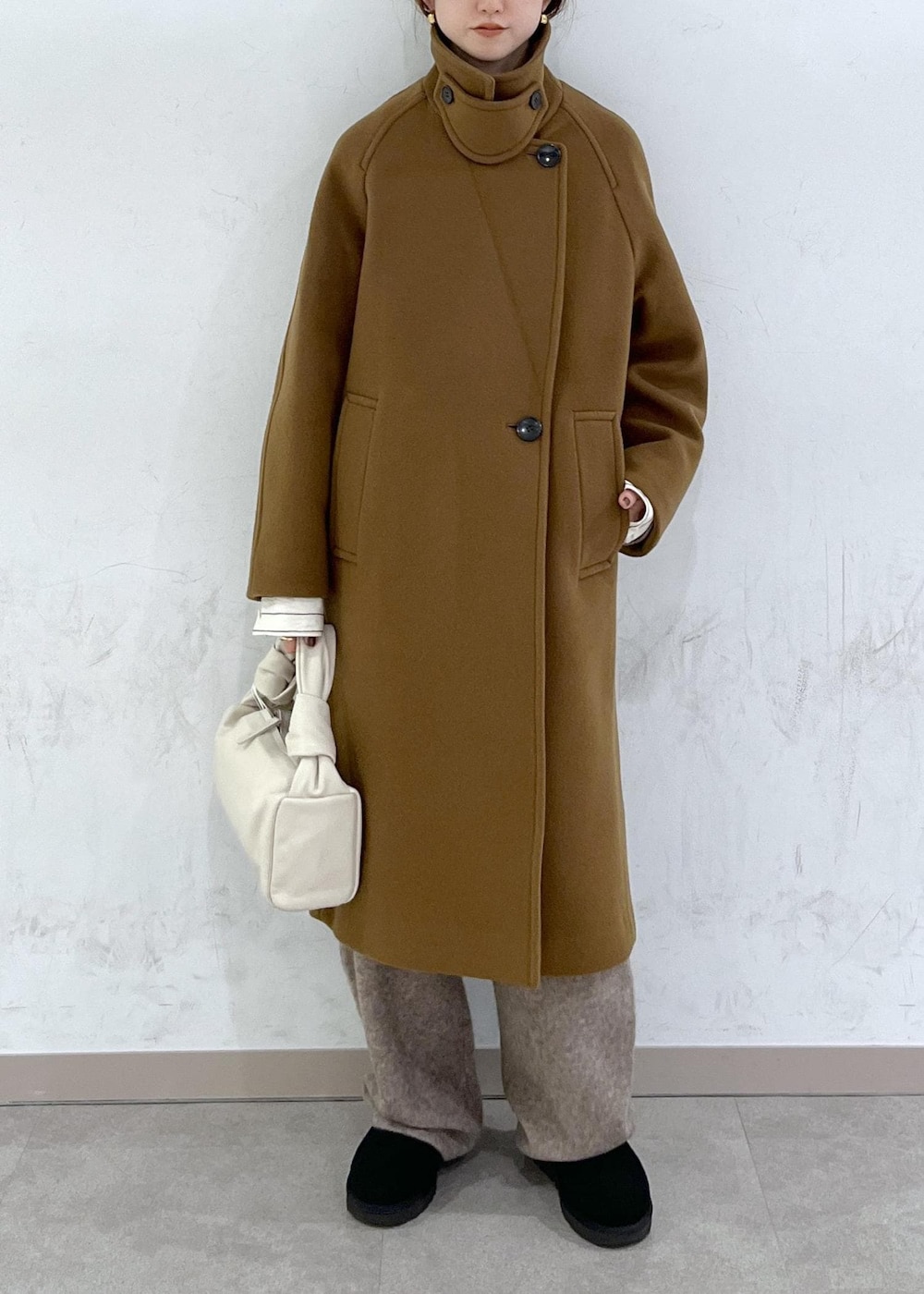 ホワイト系のハンドバッグ、イエロー系のステンカラーコート、ベージュ系のニット/セーターを着用したレディースの秋コーディネートの7枚目の写真