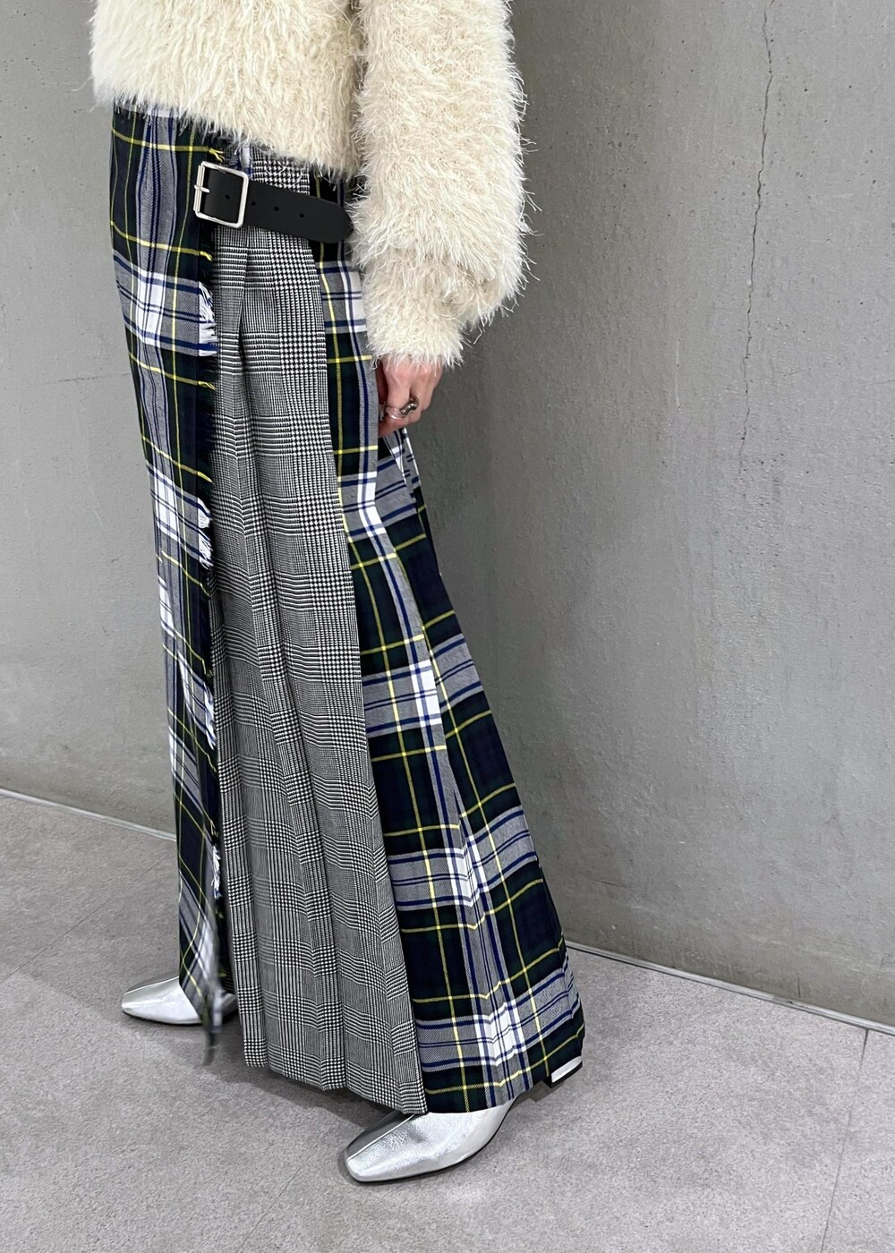 シルバー系のブーツ、ホワイト系のニット/セーター、グリーン系のスカートを着用したレディースの秋コーディネートの7枚目の写真