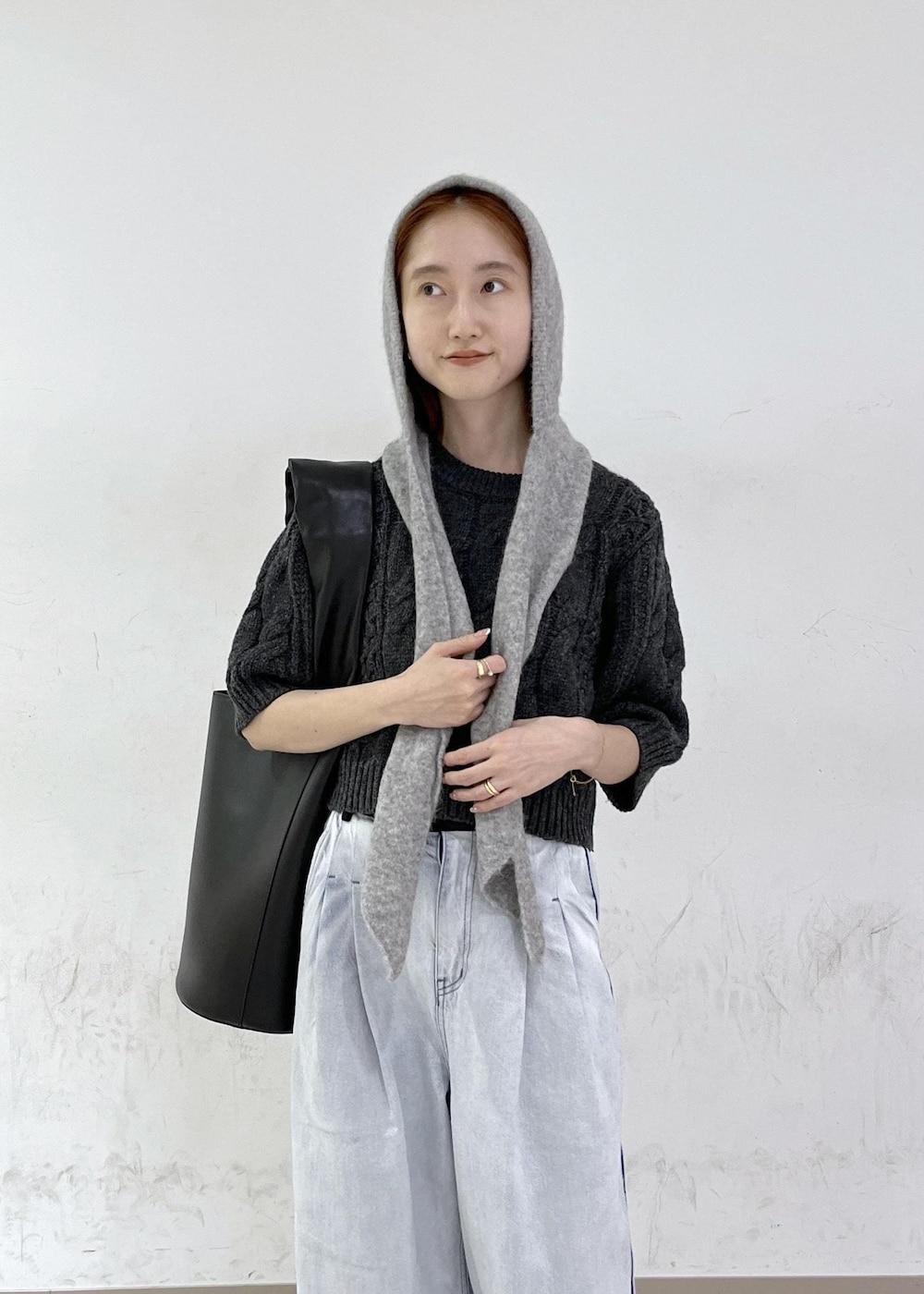 ブルー系のデニムパンツ、ブラック系のショルダーバッグ、グレー系のニット/セーターを着用したレディースの秋コーディネートの7枚目の写真