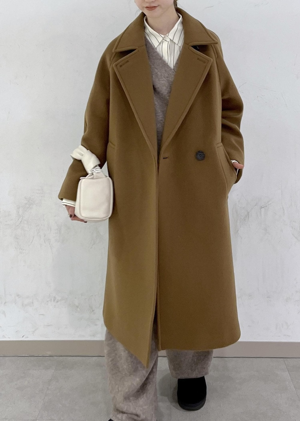 ホワイト系のハンドバッグ、イエロー系のステンカラーコート、ベージュ系のニット/セーターを着用したレディースの秋コーディネートの5枚目の写真