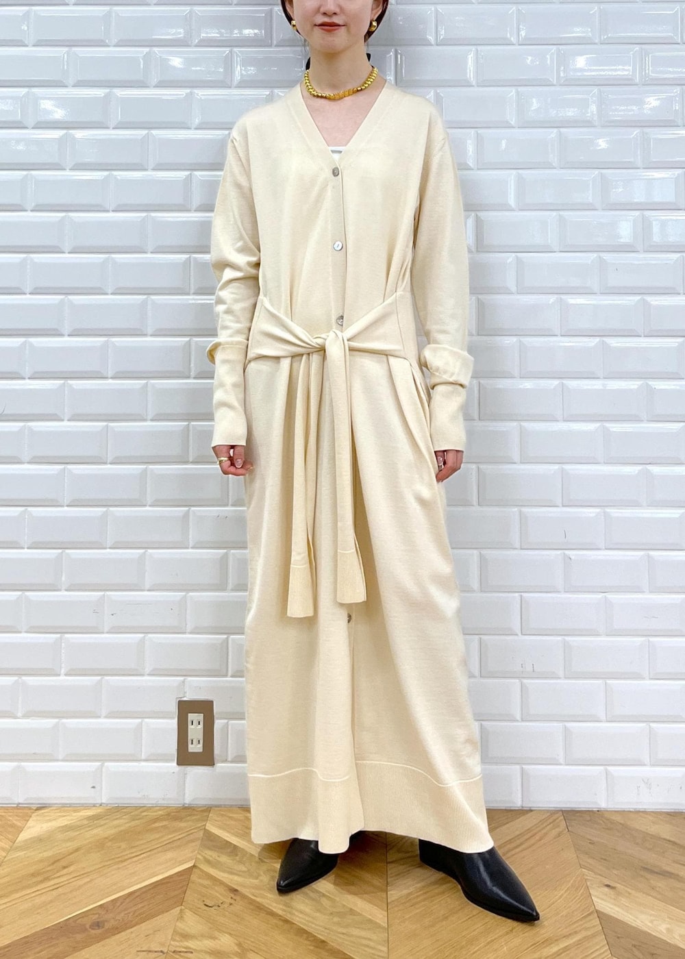 ブラック系のブーツ、ホワイト系のワンピース、ホワイト系のダウンジャケット/コートを着用したレディースの秋コーディネートの8枚目の写真