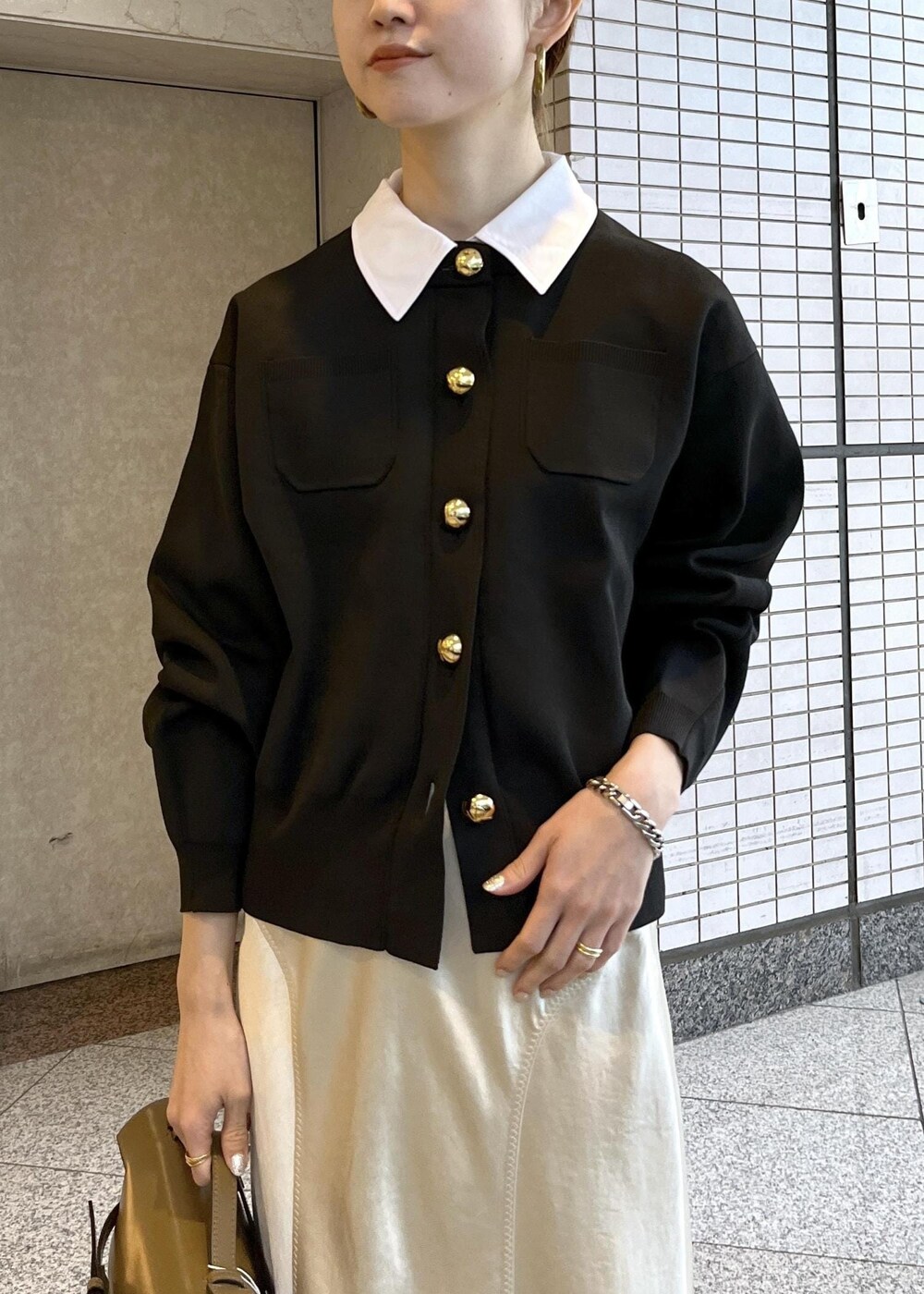 ベージュ系のスカート、ベージュ系のショルダーバッグ、ブラック系のローファーを着用したレディースの冬コーディネートの7枚目の写真