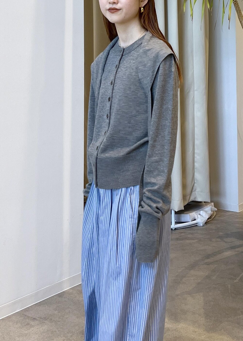 ブラウン系のサンダル、ブルー系のスラックス、グレー系のカーディガン/ボレロを着用したレディースの秋コーディネートの9枚目の写真