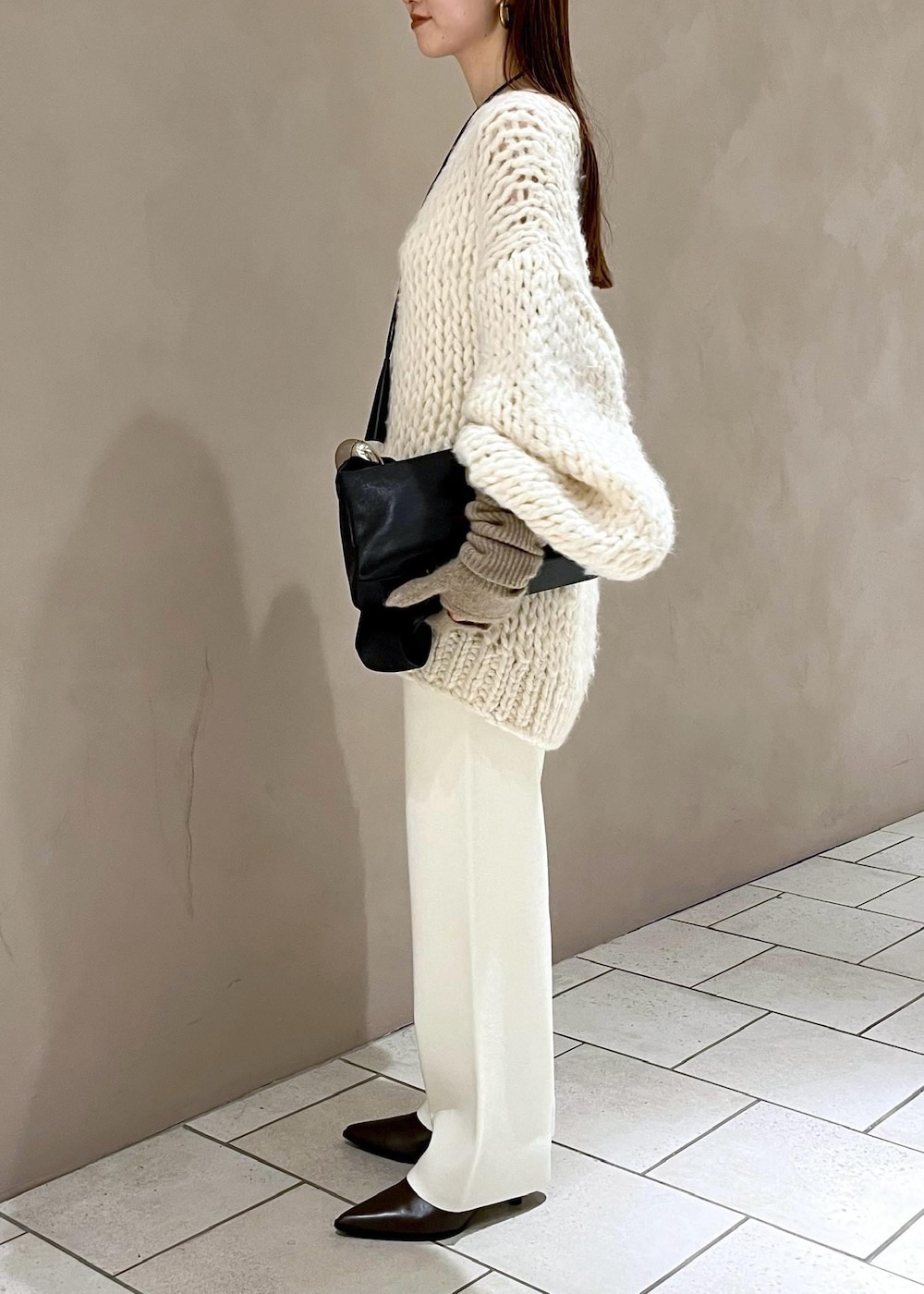 ブラウン系のブーツ、ホワイト系のその他パンツ、ホワイト系のニット/セーターを着用したレディースの冬コーディネートの3枚目の写真