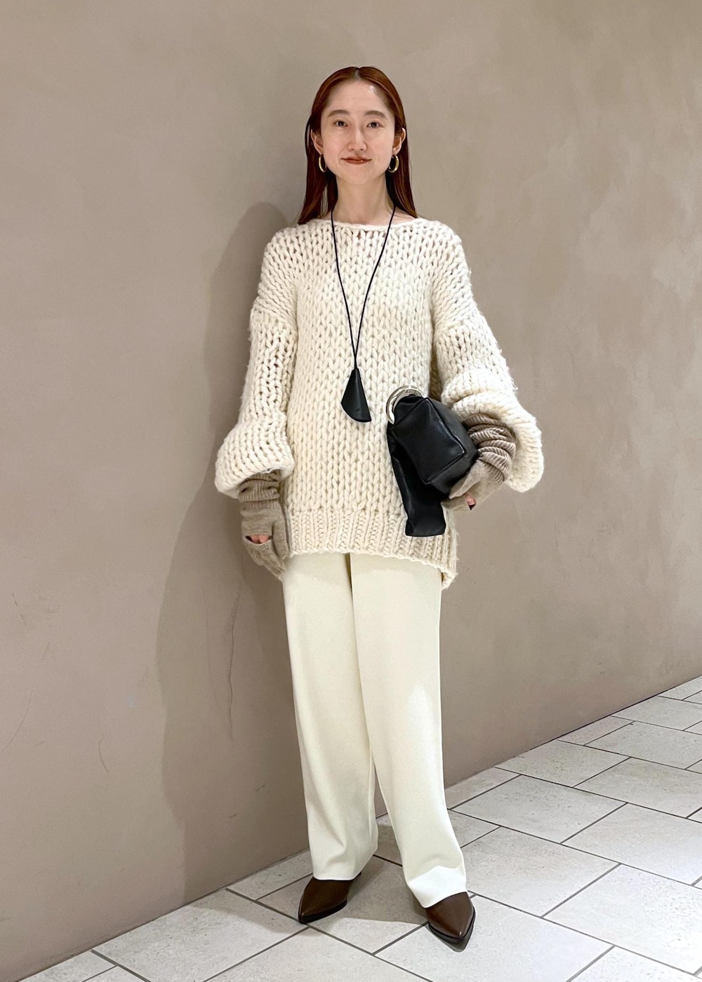 ブラウン系のブーツ、ホワイト系のその他パンツ、ホワイト系のニット/セーターを着用したレディースの冬コーディネートの2枚目の写真