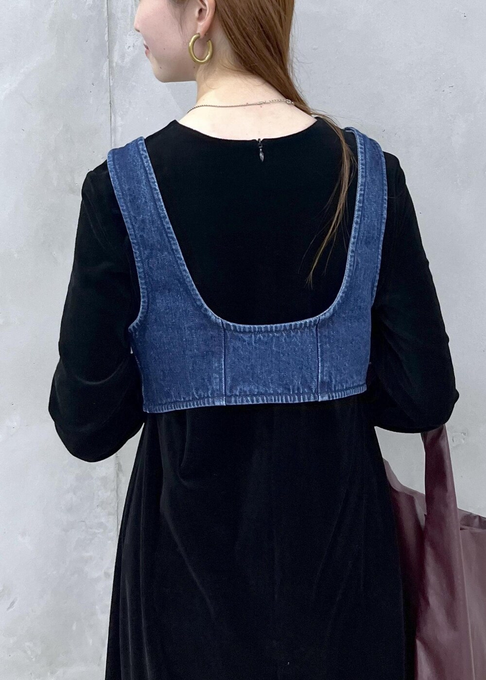 ブラック系のブーツ、ブラック系のワンピース、ブルー系のベストを着用したレディースの秋コーディネートの7枚目の写真