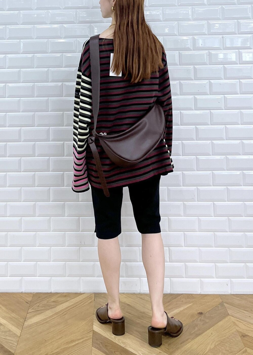 ブラウン系のサンダル、ブラック系のその他パンツ、レッド系のショルダーバッグを着用したレディースの秋コーディネートの3枚目の写真