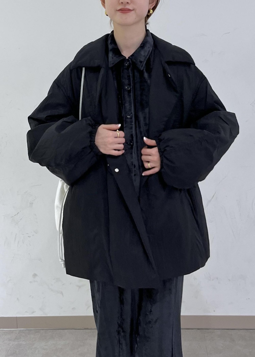 ホワイト系のブーツ、ブラック系のブルゾン、ホワイト系のハンドバッグを着用したレディースの秋コーディネートの7枚目の写真