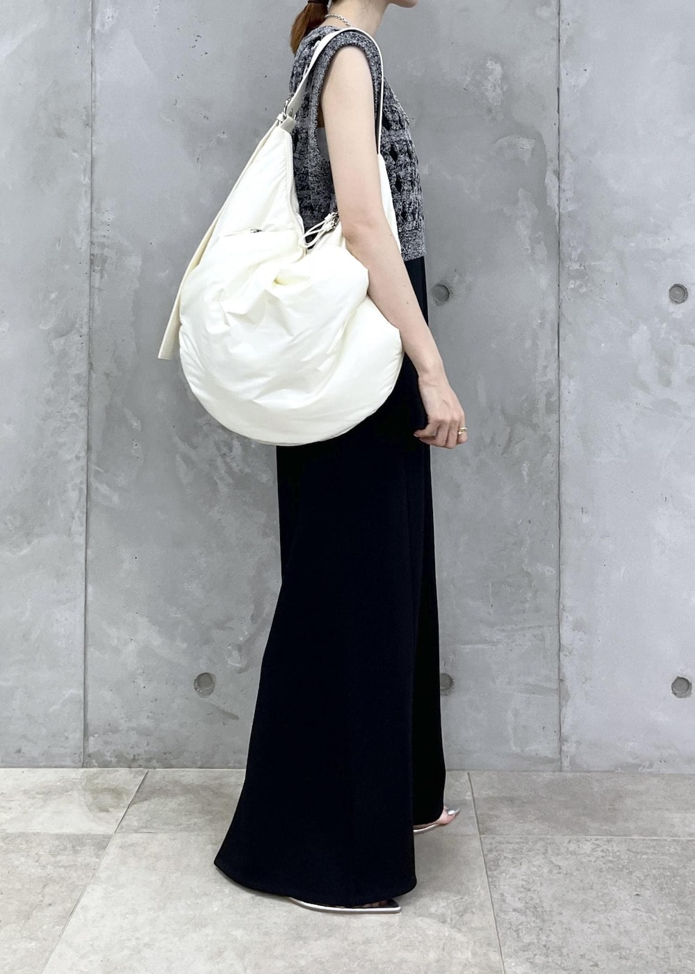 シルバー系のサンダル、ブラック系のワンピース、シルバー系のネックレスを着用したレディースの夏コーディネートの3枚目の写真