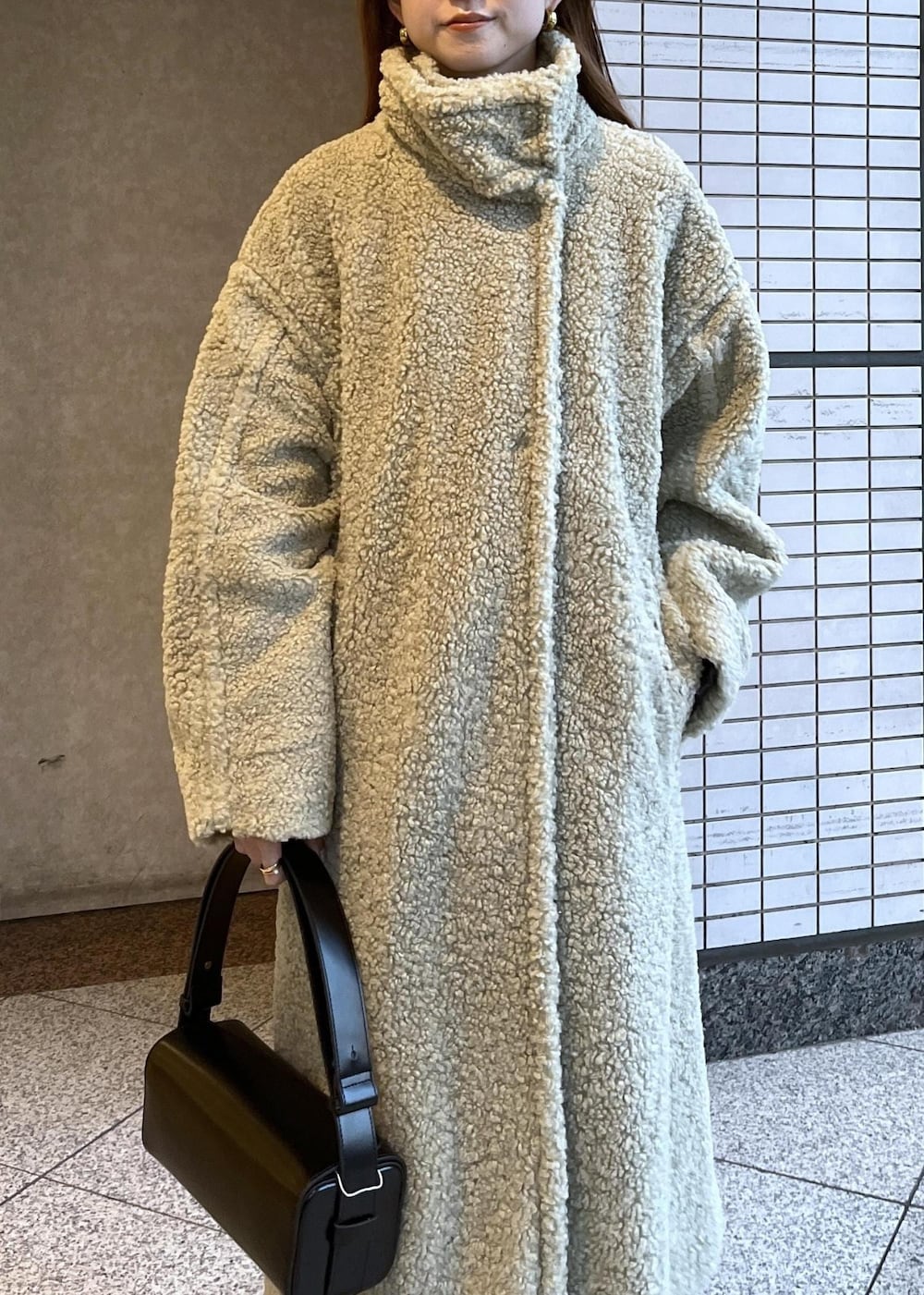 ブラック系のブーツ、ホワイト系のカーディガン/ボレロ、グリーン系のその他アウターを着用したレディースの冬コーディネートの8枚目の写真