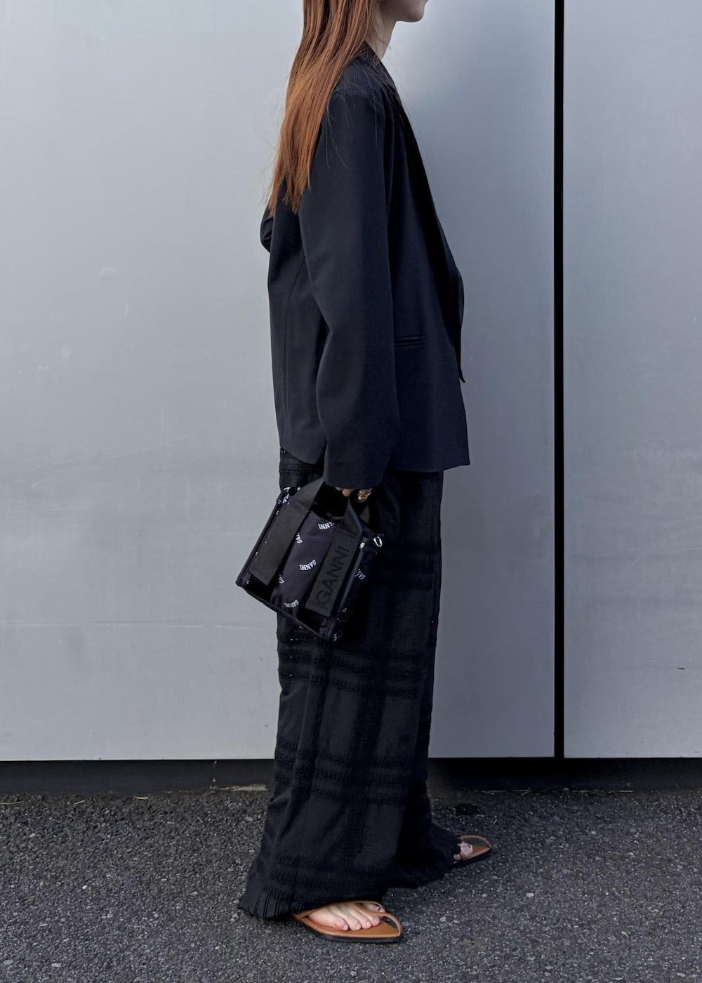 イエロー系のサンダル、ブラック系のトートバッグ、ホワイト系のネックレスを着用したレディースの冬コーディネートの3枚目の写真