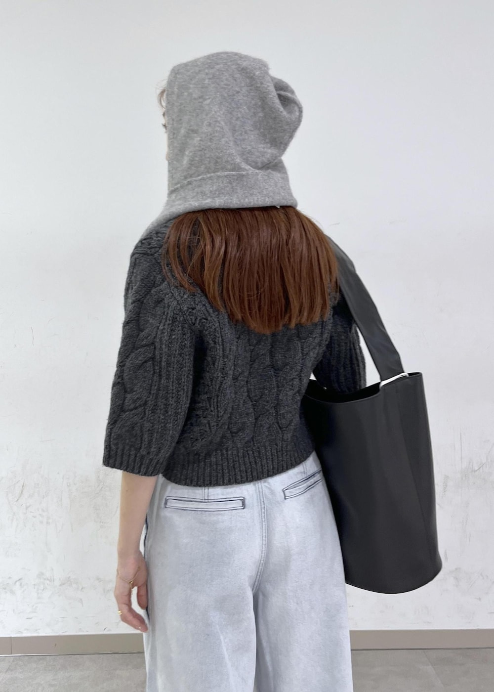 ブルー系のデニムパンツ、ブラック系のショルダーバッグ、グレー系のニット/セーターを着用したレディースの秋コーディネートの9枚目の写真