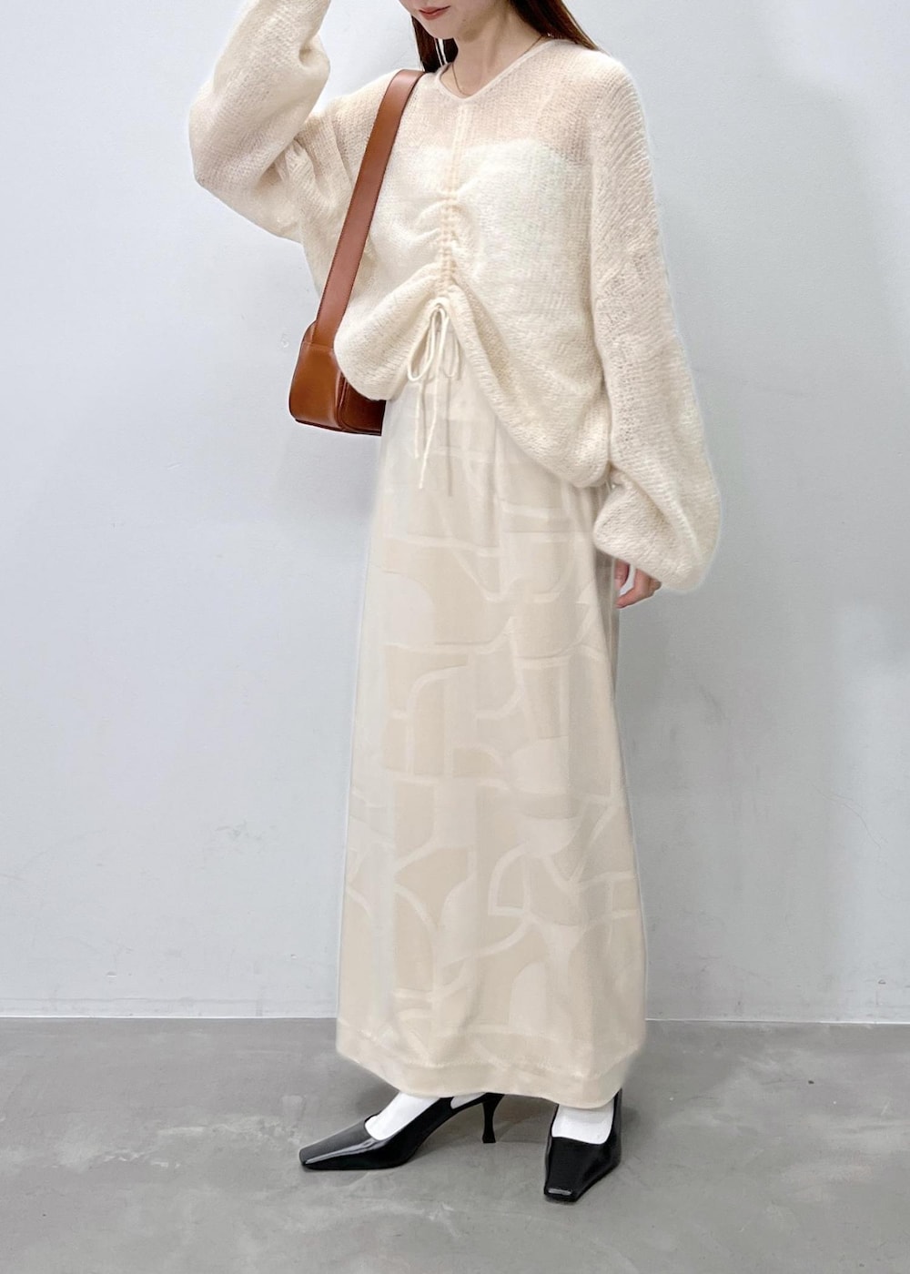 ホワイト系のスカート、ベージュ系のニット/セーター、ブラウン系のショルダーバッグを着用したレディースの夏コーディネートの4枚目の写真