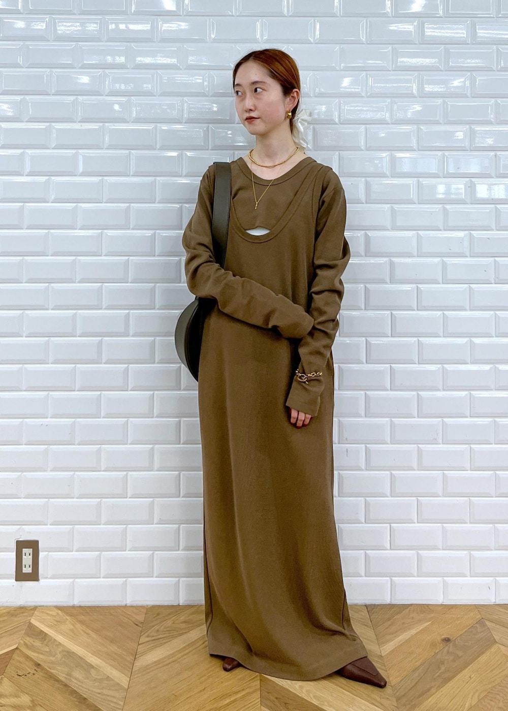 レッド系のショルダーバッグ、ブラウン系のサンダル、ブラウン系のワンピースを着用したレディースの夏コーディネートの2枚目の写真