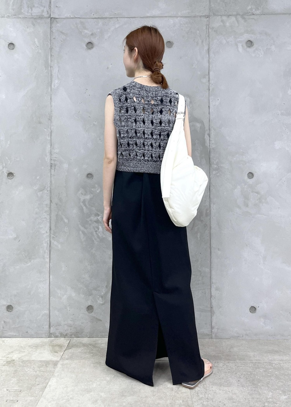 シルバー系のサンダル、ブラック系のワンピース、シルバー系のネックレスを着用したレディースの夏コーディネートの4枚目の写真