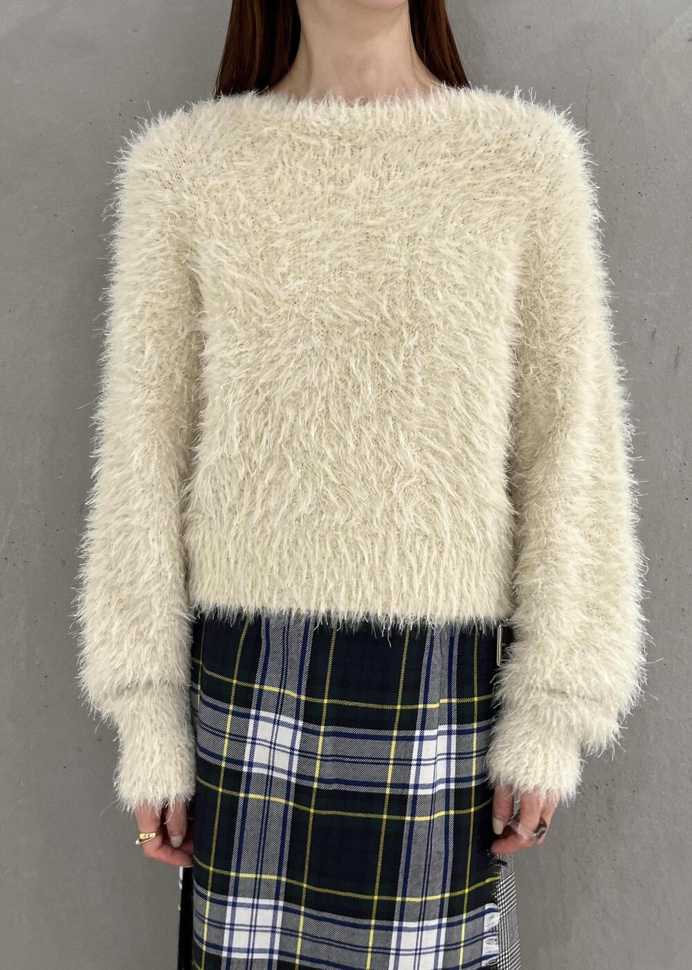 シルバー系のブーツ、ホワイト系のニット/セーター、グリーン系のスカートを着用したレディースの秋コーディネートの4枚目の写真