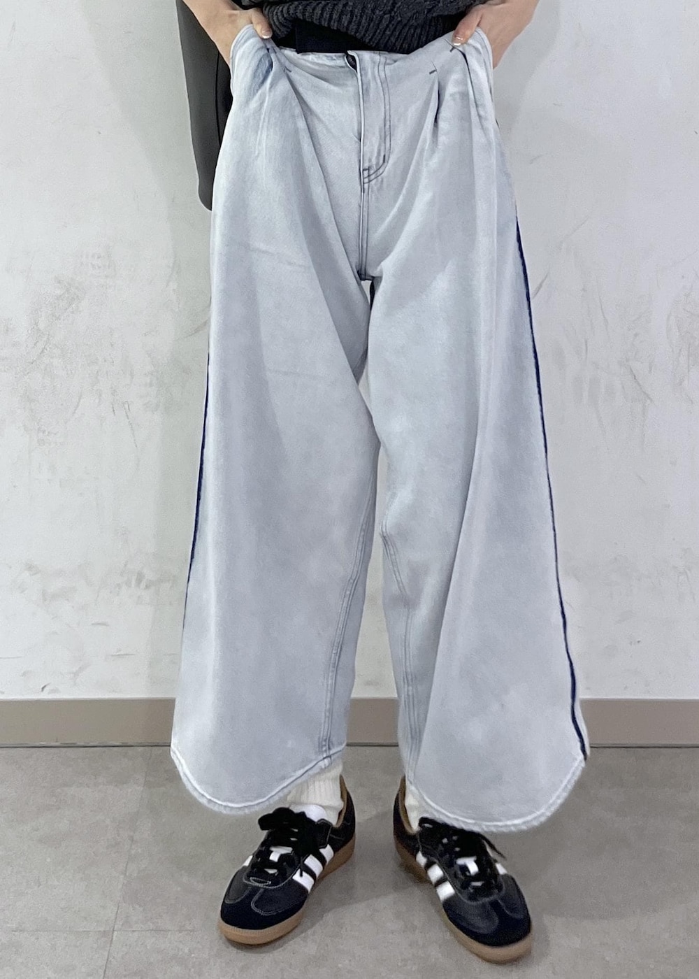 ブルー系のデニムパンツ、ブラック系のショルダーバッグ、グレー系のニット/セーターを着用したレディースの秋コーディネートの6枚目の写真