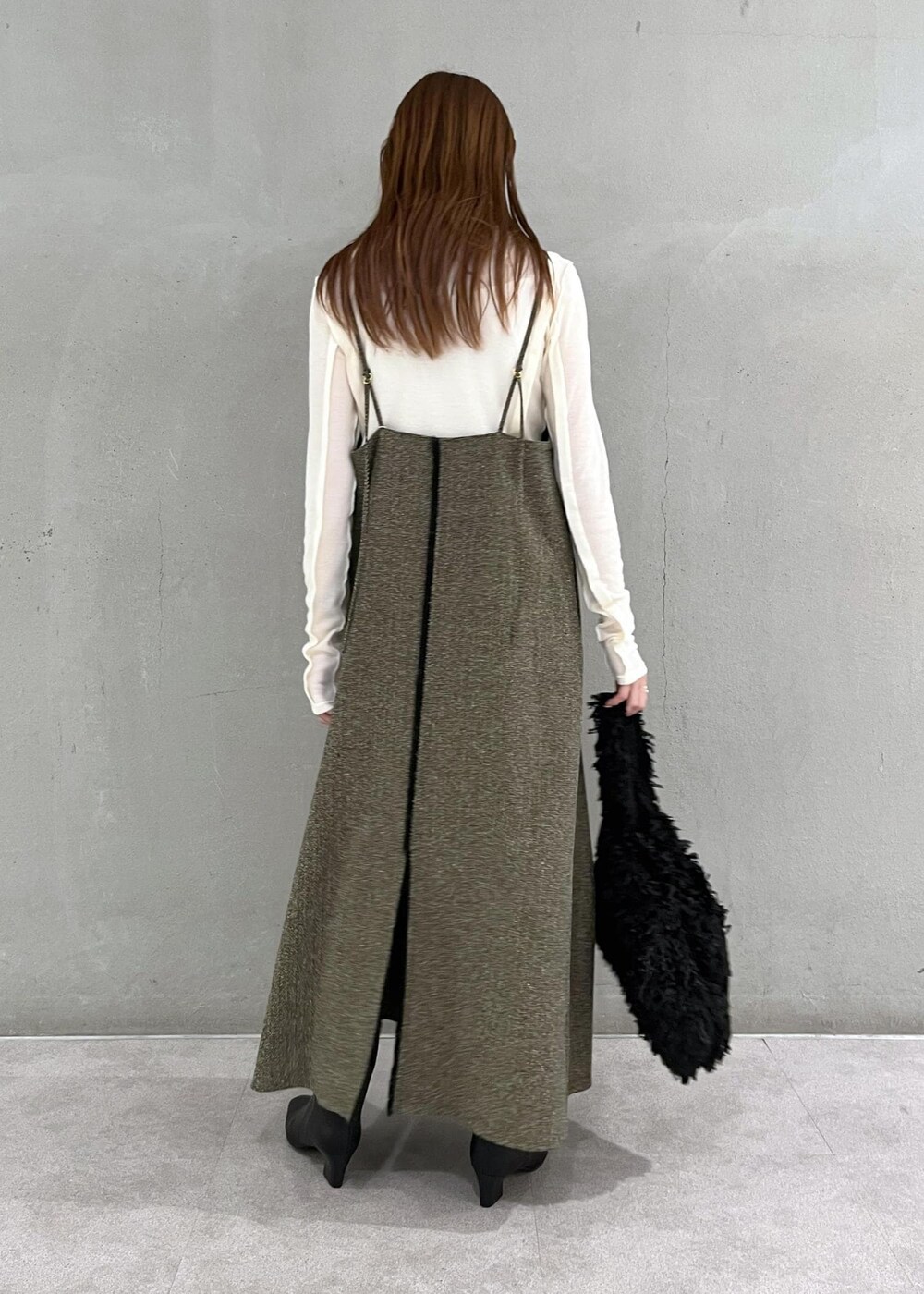 ブラック系のブーツ、ベージュ系のワンピース、ホワイト系のTシャツ/カットソーを着用したレディースの秋コーディネートの2枚目の写真