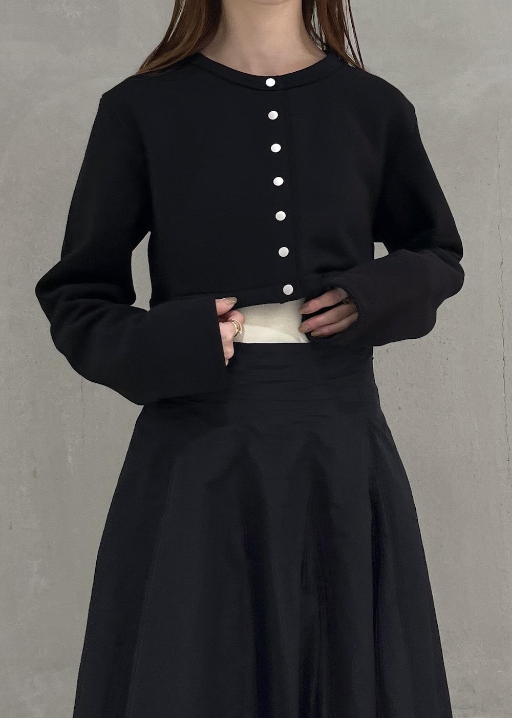 ブラック系のカーディガン/ボレロ、ホワイト系のキャミソール、ブラック系のスカートを着用したレディースの秋コーディネートの4枚目の写真