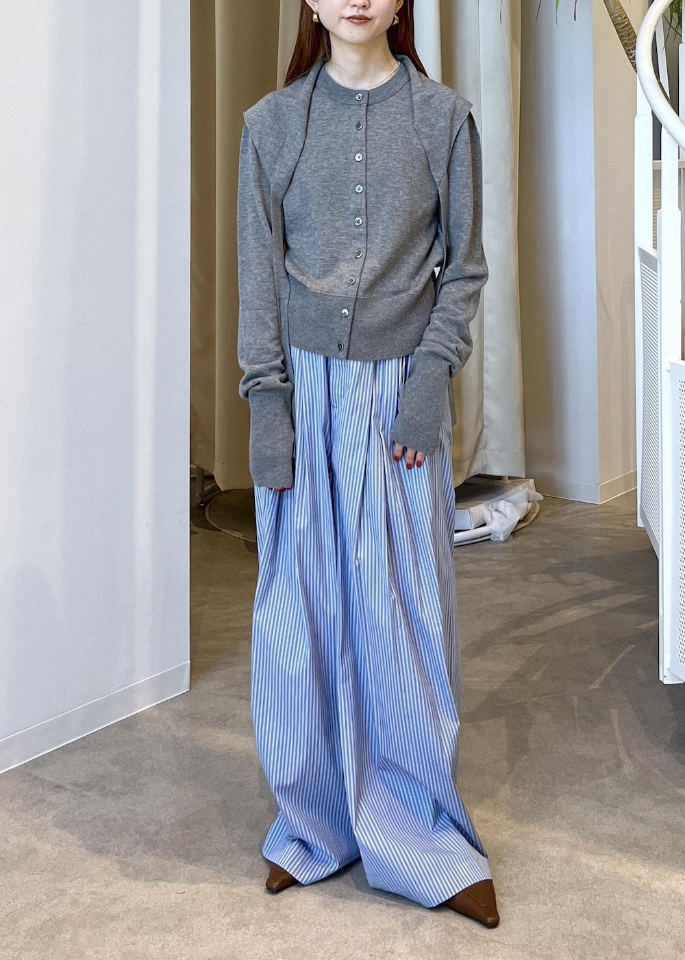 ブラウン系のサンダル、ブルー系のスラックス、グレー系のカーディガン/ボレロを着用したレディースの秋コーディネートの3枚目の写真