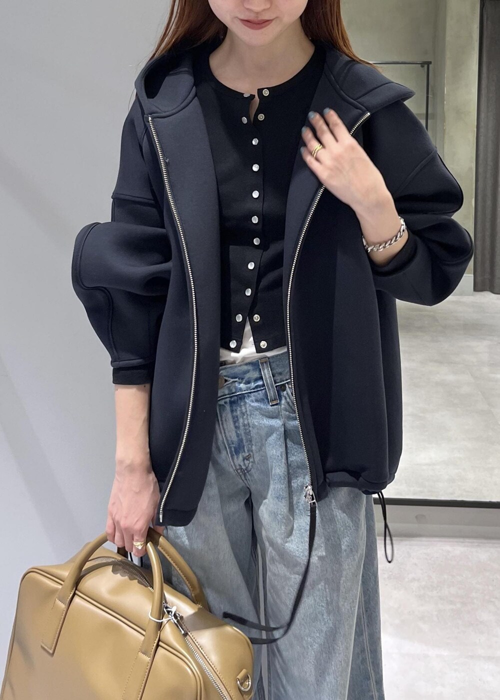 ブラウン系のボストンバッグ、ブラック系のブルゾンを着用したレディースの春コーディネートの4枚目の写真