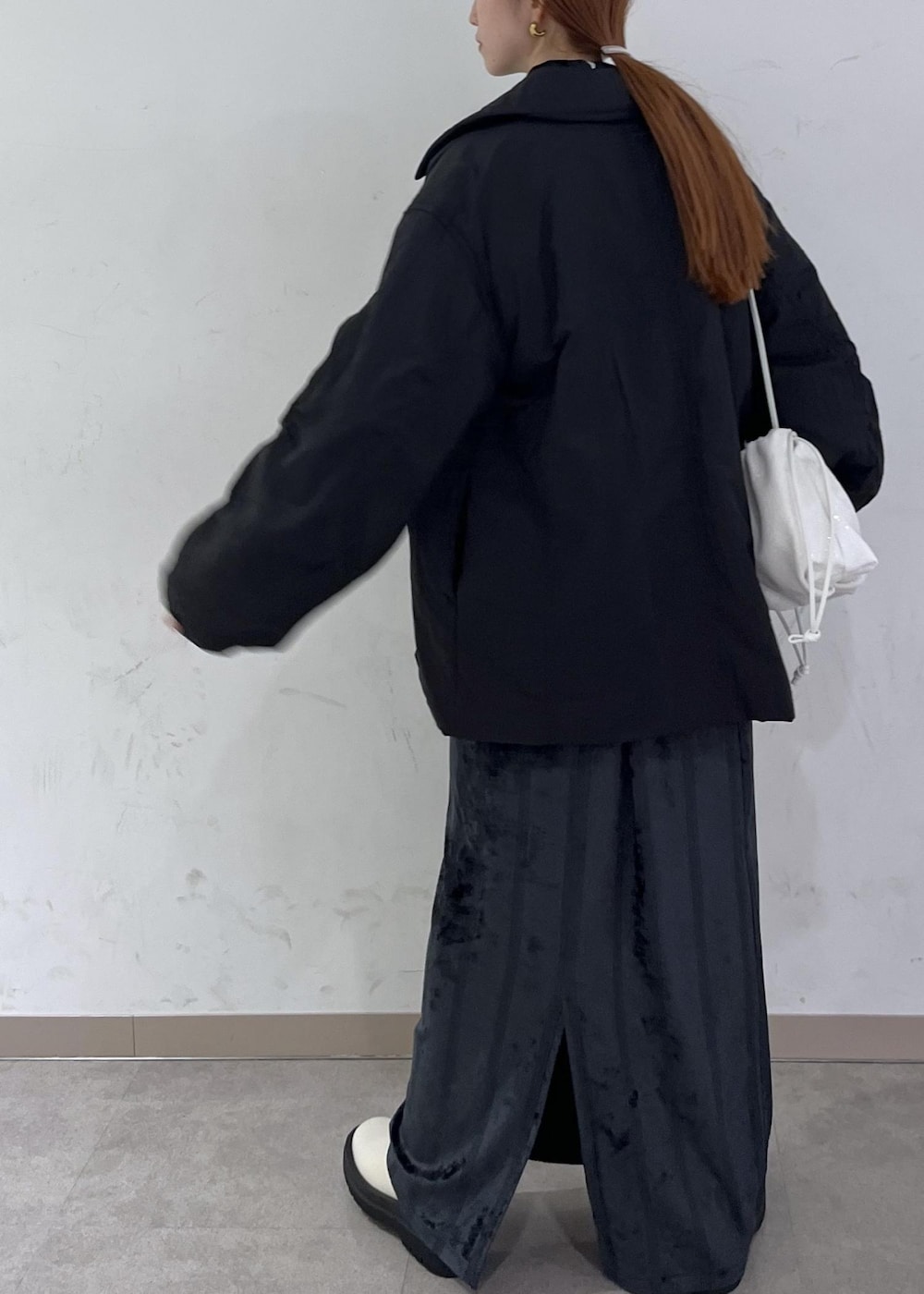 ホワイト系のブーツ、ブラック系のブルゾン、ホワイト系のハンドバッグを着用したレディースの秋コーディネートの5枚目の写真