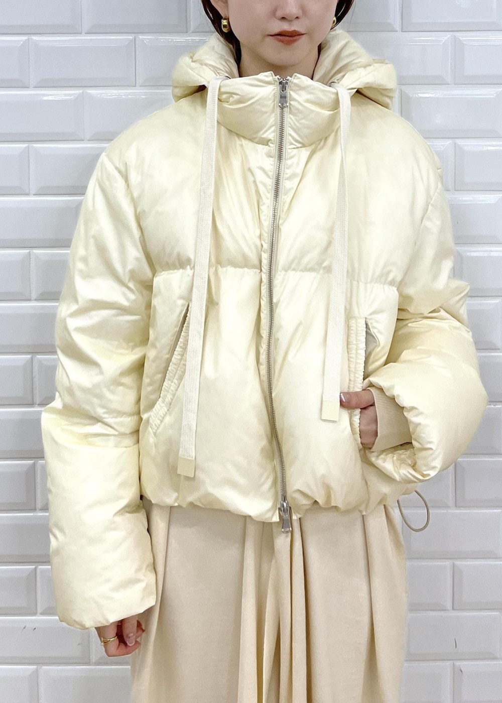 ブラック系のブーツ、ホワイト系のワンピース、ホワイト系のダウンジャケット/コートを着用したレディースの秋コーディネートの5枚目の写真