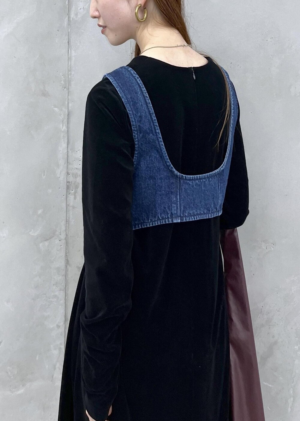 ブラック系のブーツ、ブラック系のワンピース、ブルー系のベストを着用したレディースの秋コーディネートの8枚目の写真