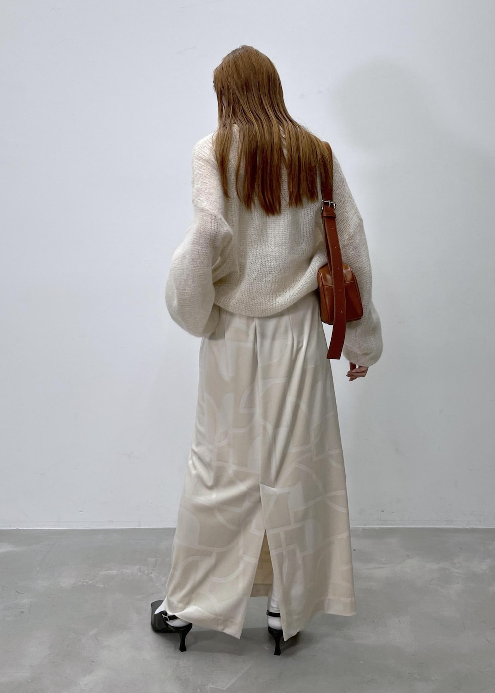 ホワイト系のスカート、ベージュ系のニット/セーター、ブラウン系のショルダーバッグを着用したレディースの夏コーディネートの5枚目の写真