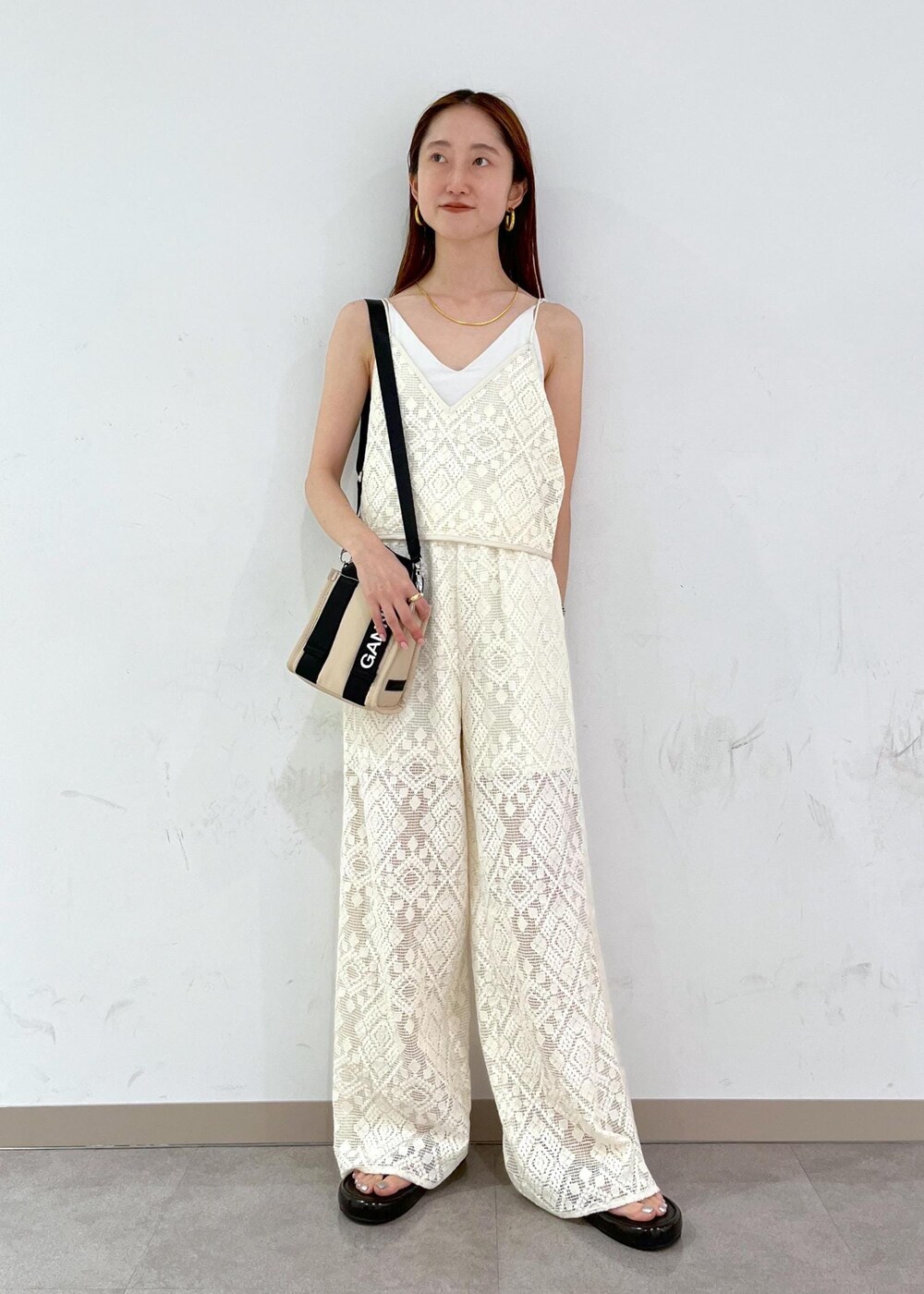 ブラック系のサンダル、ホワイト系のその他パンツ、ホワイト系のキャミソールを着用したレディースの夏コーディネートの2枚目の写真