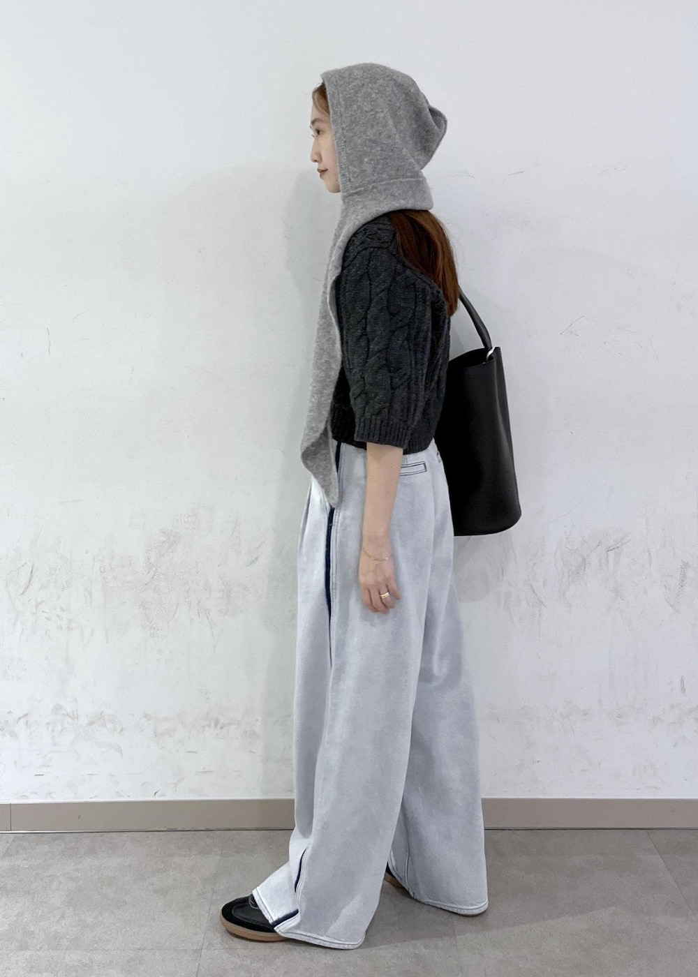 ブルー系のデニムパンツ、ブラック系のショルダーバッグ、グレー系のニット/セーターを着用したレディースの秋コーディネートの3枚目の写真