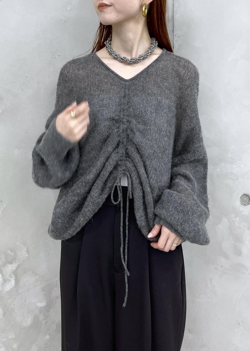 ブラック系のサンダル、グレー系のニット/セーター、ブラック系のスラックスを着用したレディースの夏コーディネートの2枚目の写真