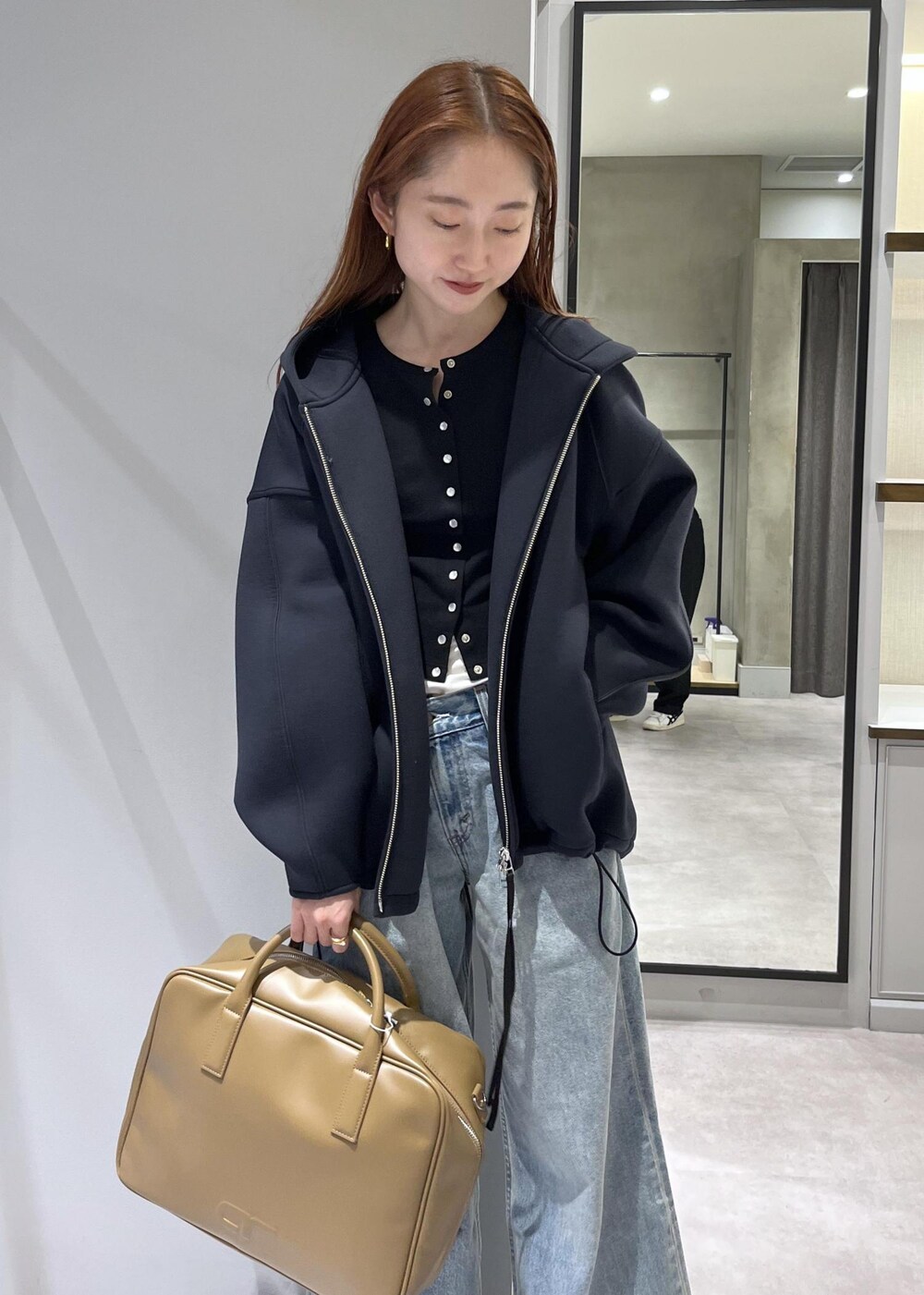 ブラウン系のボストンバッグ、ブラック系のブルゾンを着用したレディースの春コーディネートの5枚目の写真