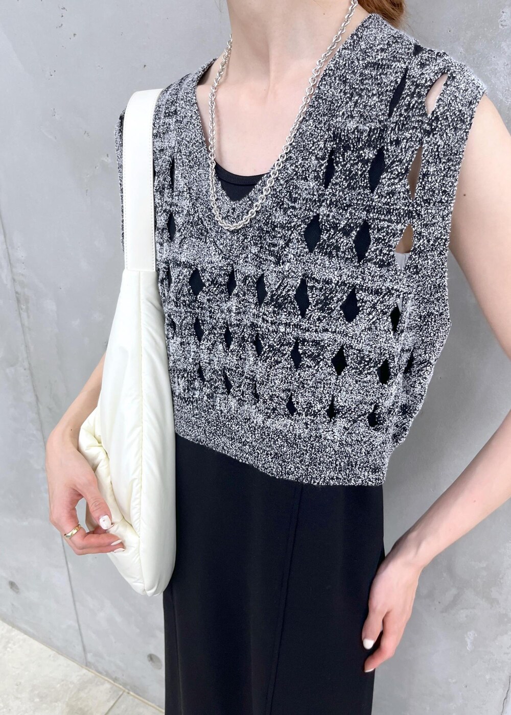 シルバー系のサンダル、ブラック系のワンピース、シルバー系のネックレスを着用したレディースの夏コーディネートの5枚目の写真