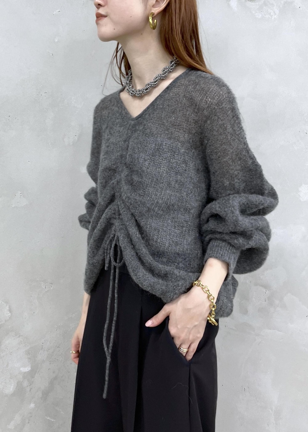 ブラック系のサンダル、グレー系のニット/セーター、ブラック系のスラックスを着用したレディースの夏コーディネートの3枚目の写真