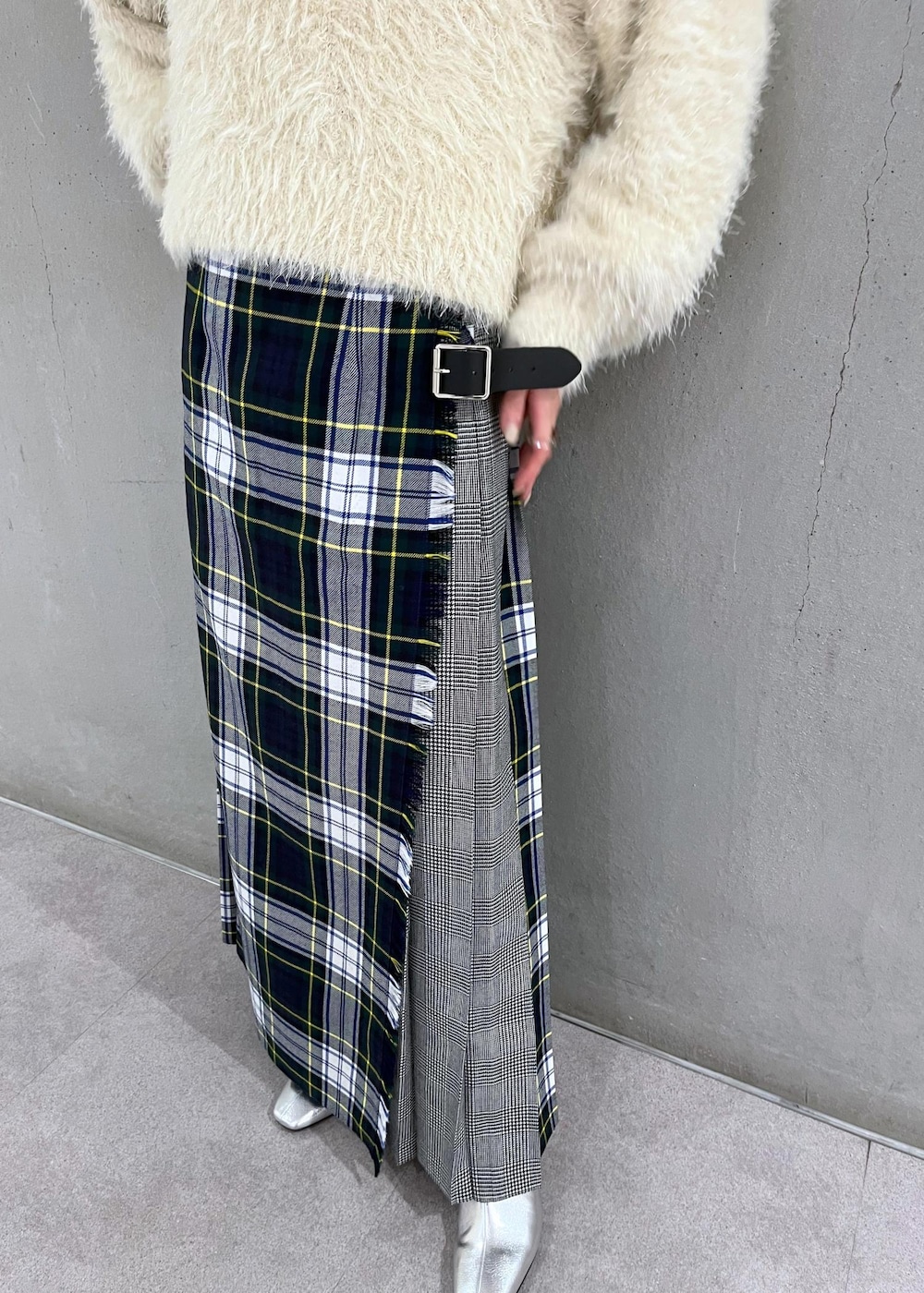 シルバー系のブーツ、ホワイト系のニット/セーター、グリーン系のスカートを着用したレディースの秋コーディネートの6枚目の写真