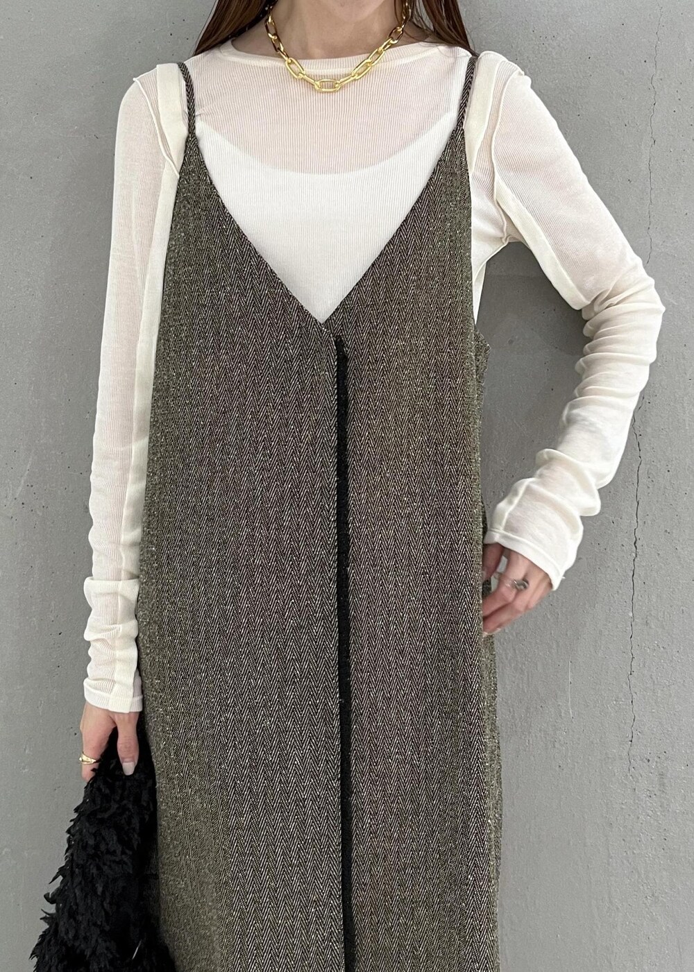 ブラック系のブーツ、ベージュ系のワンピース、ホワイト系のTシャツ/カットソーを着用したレディースの秋コーディネートの4枚目の写真